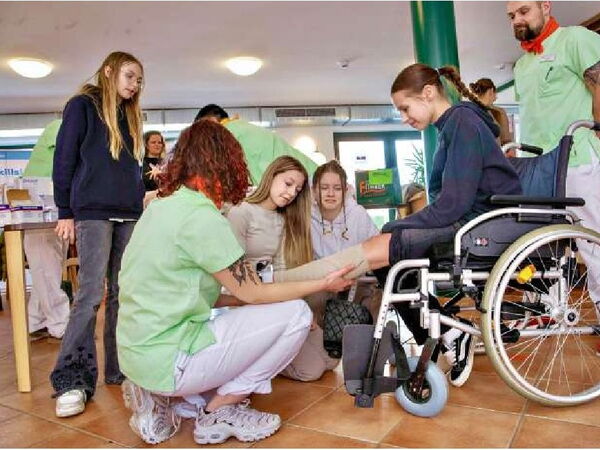 Hanna ( links) vom Pflegeteam im Amalienhof erklärt Fabienne zur Azubimesse einen Kompressionsverband. Die jungen Interessentinnen erhielten Einblicke in den Alltag des Teams.